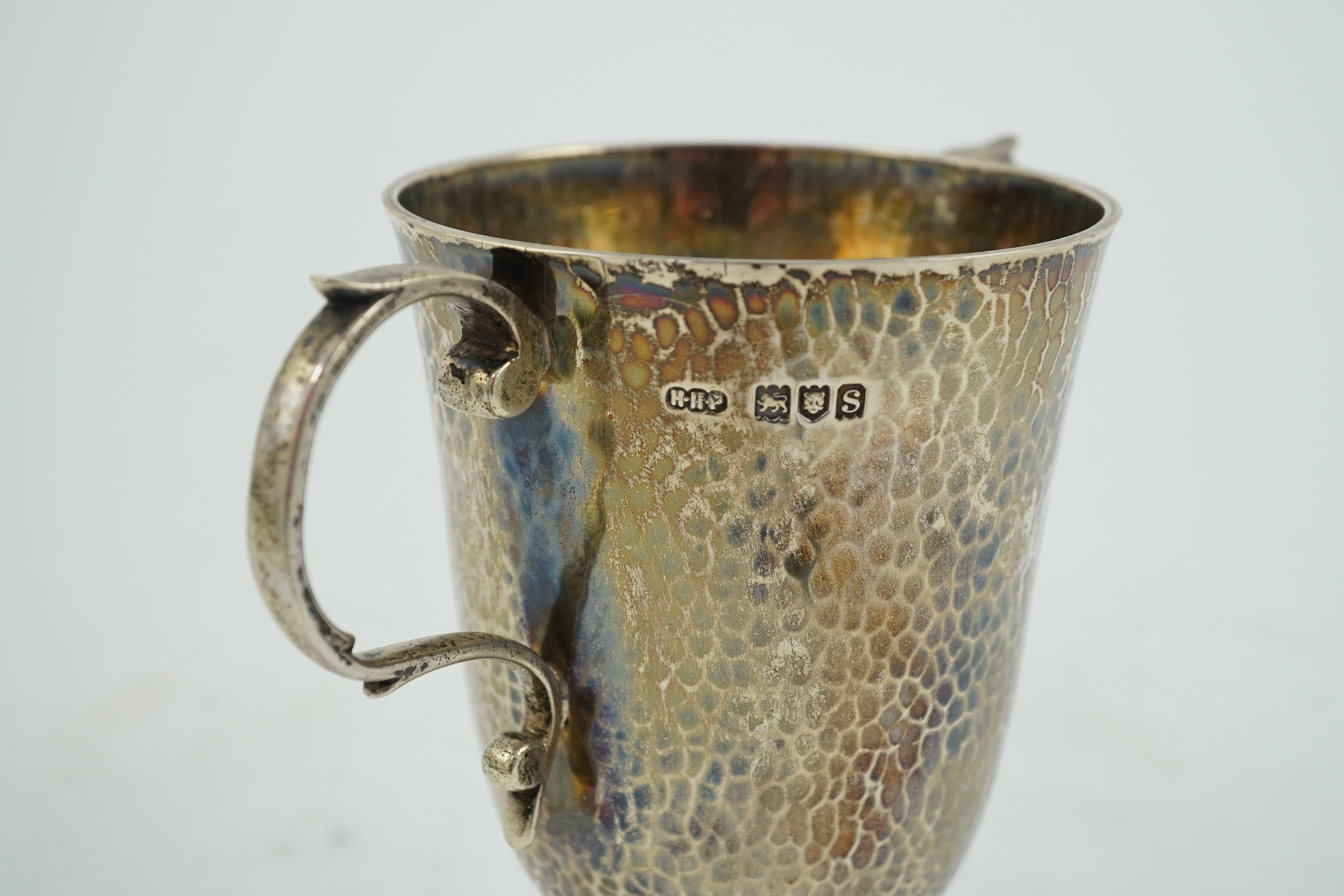 A George V planished silver two handled pedestal cup, by Henry Hodson Plante